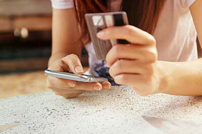 En kvinna använder rikskuponger med app och betalkort